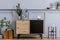 Modern scandinavian home interior with design wooden commode, big cement letter, cacti, plants, decoration,  lamp, shelf.