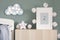 The modern scandinavian newborn baby room with mock up photo frame and clouds. Hanging cotton flags and white stars. Minimalist.