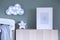 The modern scandinavian newborn baby room with mock up photo frame and clouds. Hanging cotton flags and white stars. Minimalistic