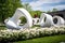 modern sculpture garden featuring sleek and abstract sculptures among blooming flowers