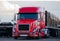 Modern semi truck flat bed trailer with cargo on parking lot