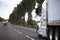 Modern semi truck on wide highway stretching into distance