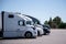 Modern semi trucks stand in row on truck stop parking space