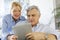 Modern senior couple using tablet at home