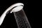 Modern shower head with running water isolated on black