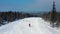 Modern ski resort in pine forest aeria, view from above. Footage. Young group of people snowboarding and skiing down the