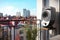 a modern sleek speaker on an apartment balcony overlooking a busy street