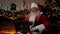 Modern smiling Santa Claus greets talks to children online laptop video call