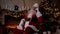 Modern smiling Santa Claus talks to children on mobile phone, Christmas holidays