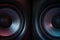 Modern sound speakers in neon light as background, closeup