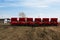 Modern sowing seeds machine. Farmer tractor seeding. Red combine plow. Sowing crops at agricultural fields in spring.