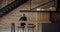 Modern and spacious wooden kitchen room with wall bricks and black staircase.