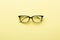Modern spectacles eye glass isolated on yellow background.