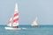 Modern sport catamaran and traditional wooden dhow boat sailing near Jambiani beach, Zanzibar