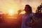 Modern sporty woman drinking water in park at dawn after intense jogging workout