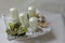 Modern square shaped advent wreath with white candles and nature decoration