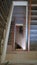 Modern stairwell in a residential building. Staircase in perspective. Gray ceramic tile. Common staircase with a brown wooden