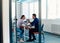 In a modern startup office, a businessman and a businesswoman business colleagues engage in a symbolic arm-wrestling