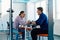 In a modern startup office, a businessman and a businesswoman business colleagues engage in a symbolic arm-wrestling