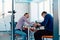 In a modern startup office, a businessman and a businesswoman business colleagues engage in a symbolic arm-wrestling