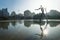 Modern statue of waterman with trident with backlight in pond at Turia River Park, Valencia, Spain