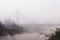 Modern steel footbridge over a river on a foggy autumn morning