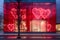 Modern storefront adorned with large red heart decorations for Valentine& x27;s Day