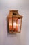 Modern streamlined mirror copper wall lamp. Metal classic lantern on gray background
