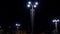 Modern street lights with garlands shine brightly at night. Stock footage. Beautiful modern design of street lights