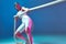 Modern strong sports girl pulling white rope training endurance in pink neon light. Long exposure. Fitness, wellness