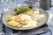 Modern style Atlantic fried salmon filet with traditional white asparagus in sauce hollandaise and lettuce on a design plate