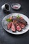 Modern style barbecue dry aged wagyu entrecote beef steak with lettuce and tomatoes on a design plate