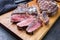 Modern style barbecue dry aged wagyu entrecote beef steak sliced with salt and spice on modern design wooden board