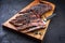 Modern style barbecue wagyu bavette beef steak with black salt on a rustic design wooden board