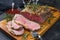 Modern style Commonwealth Sunday roast with sliced cold cuts roast beef with herbs and red wine on a design wooden board