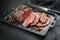 Modern style Commonwealth Sunday roast with sliced cold cuts roast beef with vegetable chips and herbs on a design tray