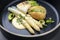 Modern style German fried cod fish filet with white asparagus in sauce hollandaise and roast potatoes