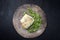 Modern style gourmet fried European skrei cod fish filet with purslane lettuce and herbs on a rustic design plate