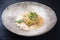Modern style gourmet fried skrei cod fish in Thai curry with chili and sprouts on a rustic design plate