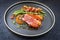 Modern style minimalistic gourmet duck breast filet with beans and bacon in orange sauce on a Nordic design plate