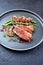 Modern style minimalistic gourmet duck breast filet with beans and bacon in orange sauce on a Nordic design plate