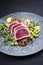 Modern style traditional Japanese gourmet seared tuna fish steak tataki with soba noodles and stir-fried vegetables