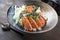 Modern style traditional Japanese salmon sashimi with rice and vegetable in a design bowl