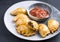 Modern style traditional South American empanada de carne with a chili dip on a design plate