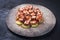 Modern style traditional Spanish pulpo a la gallega with barbecued octopus, potato chips and chili on a rustic design plate