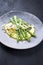 Modern style traditional steamed green asparagus with mashed potato creme and parmesan on a design plate