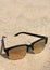 Modern sunglasses lies in the sand