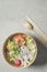 Modern sustainable food delivery with eco friendly packaging and cutlery. Healthy Asian take away food : salad bowl with salmon on