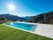 Modern swimming pool in the garden with lake and valley view