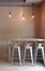 Modern table counter bar with chairs loft interior with gray tile wall and hanging decor lamps